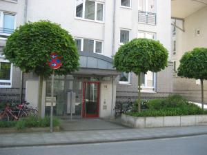 ハノーファーにあるApartment zum Relaxen - ruhig und doch zentralの赤い扉と木々の二本の建物
