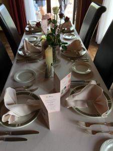 una mesa larga con platos y servilletas. en Hotel La Venerie en Virton