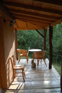 a cat sitting on a porch with chairs and a table at Chalet à Bazian in Bazian