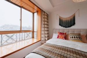 a bedroom with a bed and a large window at Xi’an Beilin·Moslem Street (Huimin Jie)· Locals Apartment 00174500 in Xi'an