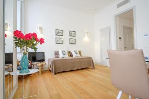 リスボンにあるSuperb Apartment in historical Centreのリビングルーム(ベッド1台、赤いバラの花瓶付)