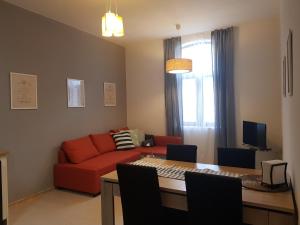 uma sala de estar com um sofá vermelho e uma mesa em Radomir Downtown Apartments em Radomir