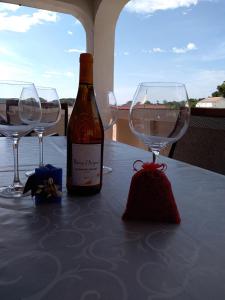 a bottle of wine sitting on a table with two wine glasses at Kampor Apartment 7 in Supetarska Draga