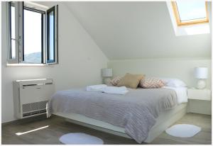 a white bedroom with a bed and a window at Holiday Home Ante in Primošten