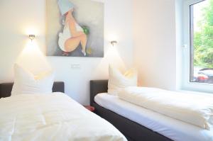 Zimmer mit 2 Betten und Wandgemälde in der Unterkunft Suite Gartenstraße im hellen Ambiente in Norderney