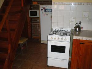 a kitchen with a white stove and a refrigerator at Cabañas Tunquelen in El Bolsón