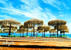 a group of straw umbrellas on the beach at Akrogiali Hotel Restaurant in Xiropigado