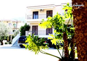 a car parked in front of a white building at Akrogiali Hotel Restaurant in Xiropigado