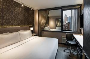 a hotel room with a bed and a desk and a window at Aliz Hotel Times Square in New York