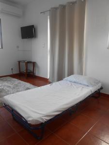 uma pequena cama num quarto com uma televisão em Studio Bibi em Gouvinhas