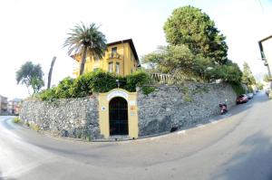 a building on a stone wall next to a street at Villa Margherita in Levanto