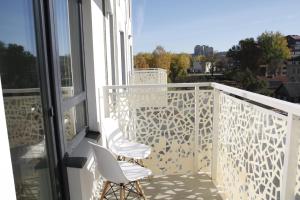 a balcony with two white chairs and a window at EVA apartment in Vilnius