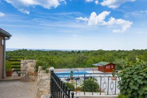 a view of a pool from a house with a fence at Meerblick Ferienhaus Julian nahe Rovinj in Rovinj
