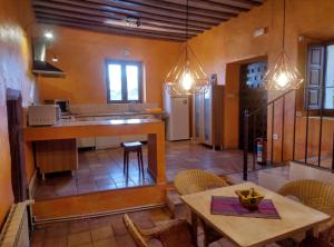 a kitchen and dining room with a table and chairs at Casas Rurales Planeta Chicote in Zafra de Záncara