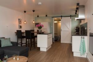 a kitchen and a living room with a table at Annadora Beach House - Free Parking in Zandvoort