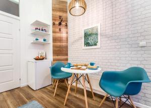 ブダペストにあるThe Blue - studio apartment in the center of Budapestのキッチン(テーブル、青い椅子2脚付)