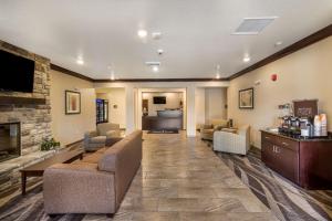 a living room with couches and a fireplace at Cobblestone Hotel & Suites - Victor in Victor