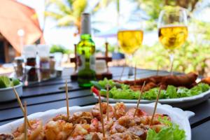 a table with plates of food and glasses of wine at Pousada Barra Velha in Maragogi