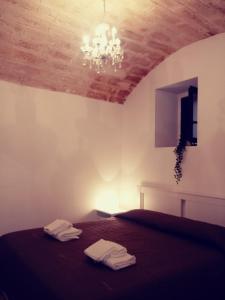 sypialnia z łóżkiem i żyrandolem w obiekcie Filioli Apartment w mieście Bari