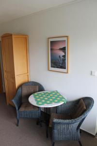 ブレーマーハーフェンにあるFewo Geesteblick - Dietmar Strauchのテーブル、椅子2脚、テーブルが備わる客室です。