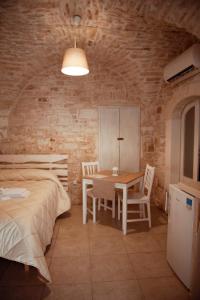une chambre avec un lit, une table et des chaises dans l'établissement Exclusive Apartments, à Martina Franca
