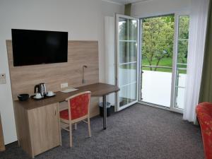 Cette chambre dispose d'un bureau, d'une télévision et d'une fenêtre. dans l'établissement Gasthof Jörns, à Diekholzen