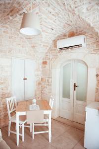 una sala da pranzo con tavolo e sedie bianchi di Exclusive Apartments a Martina Franca