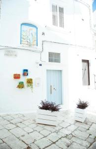 un bâtiment blanc avec deux plantes en pot devant lui dans l'établissement Exclusive Apartments, à Martina Franca 24 autres photos
