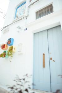 un edificio bianco con una porta blu del garage di Exclusive Apartments a Martina Franca