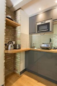 a kitchen with a sink and a microwave at Forbee Studios in London