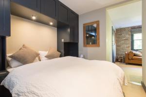 a bedroom with a large white bed and a couch at Forbee Studios in London