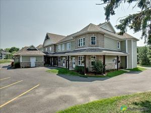 a large house on a street with a parking lot at Condo Le Champlain - 105 in Bromont
