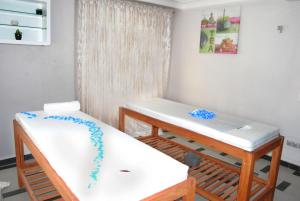 Zimmer mit 2 Betten und einem Tisch in der Unterkunft Benin Royal Hotel in Cotonou