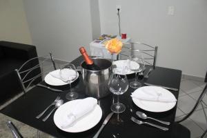 una mesa negra con platos blancos y copas de vino en Itamaraty Hotel, en Anápolis