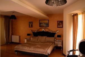 una camera da letto con un letto grande e un lampadario di DREAM Party VILLA a Bucarest