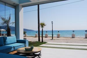 a living room with a blue couch and a view of the beach at Sunrise Studios Resort in Skala Potamias