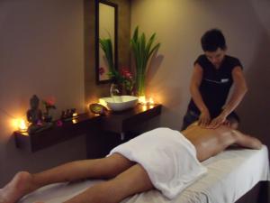 a man getting a massage on a bed with a therapist at MEN's Resort & Spa (Gay Hotel) in Siem Reap