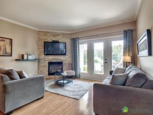 sala de estar con 2 sofás y chimenea en Condo Le Champlain - 105, en Bromont