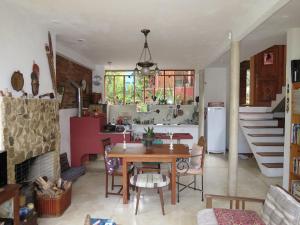 a living room with a table and a kitchen with a staircase at Casa de vidro in Petrópolis +134 photos