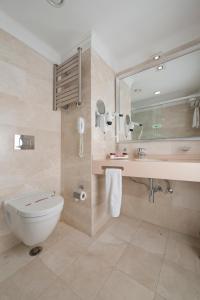 a bathroom with a toilet and a sink and a mirror at Emporium Hotel in Istanbul