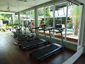 una fila de bicicletas estáticas en un gimnasio con piscina en MEN's Resort & Spa (Gay Hotel), en Siem Reap