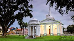 a white building with a steeple in a park at Fastbook Bendera Home 8 & 10pax in Ayer Itam