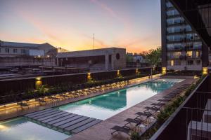 a swimming pool with chairs and a building at Quartier Dorrego in Buenos Aires