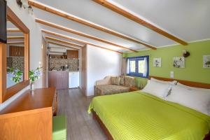 a bedroom with a green bed and a couch at Mesogeios 2000 in Ligia