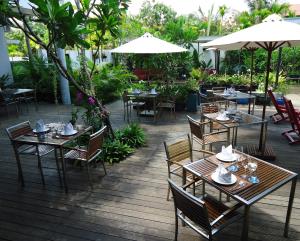 a restaurant with tables and chairs and umbrellas at MEN's Resort & Spa (Gay Hotel) in Siem Reap