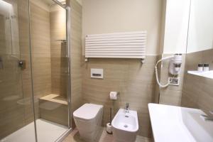 a bathroom with a shower and a toilet and a sink at Hotel Villa Margherita in Quercianella