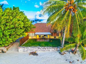 una casa en la playa con una palmera en Fare Manava en Bora Bora