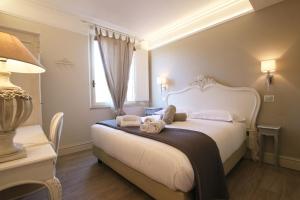 a bedroom with a white bed with towels on it at Hotel Villa Margherita in Quercianella