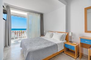 a bedroom with a bed with a view of the ocean at Mesogeios 2000 in Ligia