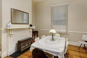 a dining room with a table and a mirror at Maeville Cottage in Broken Hill